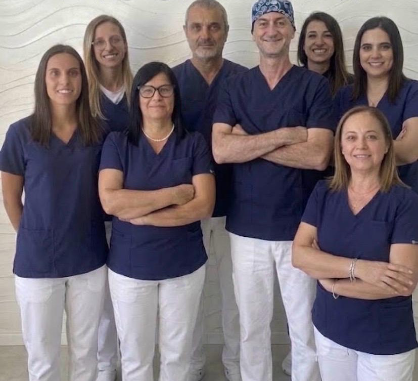 Lo staff dello studio al completo, otto persone in casacca blu